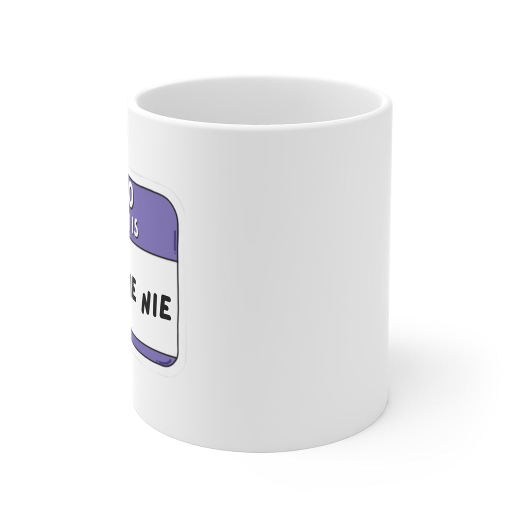 A white ceramic mug featuring a purple and white name tag graphic on the side with the text 'YOU ARE A NIE'.